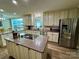 Bright kitchen features a speckled granite island, stainless steel refrigerator, and wood cabinets at 271 Ikerd Se Dr, Concord, NC 28025