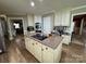 Open kitchen features a center island cooktop with recessed lights, built in ovens, and wood floors at 271 Ikerd Se Dr, Concord, NC 28025