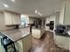 Spacious kitchen with a center island cooktop and breakfast bar with wood-look vinyl floors at 271 Ikerd Se Dr, Concord, NC 28025