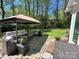 Backyard patio features stone pavers, a covered seating area, and views of the wooded property at 271 Ikerd Se Dr, Concord, NC 28025