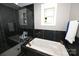 Modern bathroom with a soaking tub, stand up shower with glass doors, and black marble walls at 2757 Trent Ne Dr, Conover, NC 28613