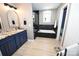 Bathroom featuring granite vanity, a soaking tub with black marble surround, and modern fixtures at 2757 Trent Ne Dr, Conover, NC 28613