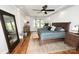 Main bedroom features a wooden bed frame, neutral decor, and large windows offering backyard views at 2757 Trent Ne Dr, Conover, NC 28613