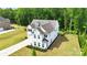 Aerial view of a two-story home with manicured lawn, fence, and mature trees, located in a wooded community at 3081 Montreaux Valley Dr, Fort Mill, SC 29707