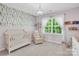 Bedroom with a crib, chair, bookshelf with toys, and one window bringing in natural light at 3081 Montreaux Valley Dr, Fort Mill, SC 29707