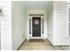 Close-up of the front door with a wreath, decorative rug, sidelights, and white siding at 3081 Montreaux Valley Dr, Fort Mill, SC 29707