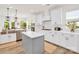 Well-lit kitchen with a center island, stainless steel appliances, white cabinets, and hardwood floors at 3081 Montreaux Valley Dr, Fort Mill, SC 29707