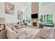 Bright living room with a stone fireplace, large windows, stylish furnishings, and soaring ceilings at 3081 Montreaux Valley Dr, Fort Mill, SC 29707