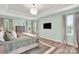 Bright main bedroom with wood floors, tray ceiling, TV, and large windows with custom blinds at 3081 Montreaux Valley Dr, Fort Mill, SC 29707