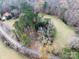 An aerial view captures a cozy home nestled within a wooded landscape and a winding road at 3713 Capricorn Rd, Lancaster, SC 29720