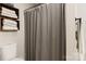 Clean bathroom featuring a toilet, shower with gray shower curtain, and stacked towels at 3713 Capricorn Rd, Lancaster, SC 29720