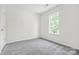 Clean bedroom with neutral carpet, large window, and bright natural light at 415 French St, Charlotte, NC 28216