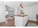 Open kitchen with wood floors, white cabinets, a butcher block island, and pendant lighting, next to living room at 415 French St, Charlotte, NC 28216