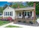 Charming home featuring a cozy front porch with chairs, a brick chimney, and lovely landscaping at 427 Spencer St, Rock Hill, SC 29730