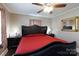 Comfortable bedroom with dark furniture, red bedding, ceiling fan, and a decorative mirror at 427 Spencer St, Rock Hill, SC 29730