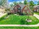 Beautiful brick home surrounded by a lush green lawn, mature trees, and a long driveway at 4333 Sawmill Trace Dr, Charlotte, NC 28213