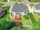 Aerial view of the house with lush backyard, patio area, well-maintained lawn, and mature trees at 4333 Sawmill Trace Dr, Charlotte, NC 28213