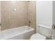 This bathroom features a neutral-tiled shower-tub and a white toilet at 4333 Sawmill Trace Dr, Charlotte, NC 28213