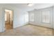 A bedroom with neutral carpet, two windows and entry into other rooms at 4333 Sawmill Trace Dr, Charlotte, NC 28213