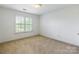 This bedroom features neutral carpet, a ceiling light, and a window with white blinds at 4333 Sawmill Trace Dr, Charlotte, NC 28213