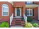 Close-up of the front entrance with brick steps, a black door, and manicured greenery at 4333 Sawmill Trace Dr, Charlotte, NC 28213