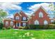 Charming brick home featuring a well-manicured lawn, mature landscaping, and classic architectural details at 4333 Sawmill Trace Dr, Charlotte, NC 28213
