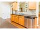 Featuring stainless steel dishwasher, and sink, this lovely kitchen has wood cabinets and hard wood floors at 4333 Sawmill Trace Dr, Charlotte, NC 28213