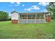 Expansive backyard showing covered porch with wooden railing and grassy area at 4462 Flat Creek Rd, Heath Springs, SC 29058