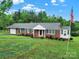 Lovely brick home with green shutters, an American flag, and lush green lawn at 4462 Flat Creek Rd, Heath Springs, SC 29058