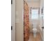 Bathroom with a floral shower curtain, toilet, window, and neutral finishes at 5016 Woodwinds Ne Dr, Hickory, NC 28601