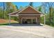 Detached garage with a covered side area, brick siding, and an open garage door showcasing interior at 5016 Woodwinds Ne Dr, Hickory, NC 28601