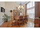 Formal dining room featuring a large window, chandelier, and hardwood floors with decorative trim at 5016 Woodwinds Ne Dr, Hickory, NC 28601