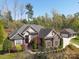 Stunning brick home with a meticulously landscaped yard and separate garage, set against a backdrop of mature trees at 5016 Woodwinds Ne Dr, Hickory, NC 28601