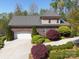 Aerial view of a two-story home featuring a brick facade, shingle roof, landscaped grounds, and an attached garage at 5016 Woodwinds Ne Dr, Hickory, NC 28601