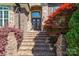 Inviting stone and brick entrance with detailed double doors, complemented by mature landscaping and brick steps at 5016 Woodwinds Ne Dr, Hickory, NC 28601