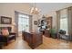 Spacious office with hardwood floors, a large desk, a bookcase, and a sitting area at 5016 Woodwinds Ne Dr, Hickory, NC 28601
