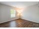 This bedroom has wood floors, a window, and a modern lamp at 523 Tribune Dr, Charlotte, NC 28214