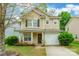 Charming two-story home featuring tan siding, black shutters, a cozy front porch, and a one-car garage at 523 Tribune Dr, Charlotte, NC 28214