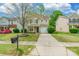 Exterior shot of a tan two-story home with well-kept lawn, a mailbox, and long concrete driveway at 523 Tribune Dr, Charlotte, NC 28214