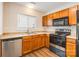 Well-equipped kitchen featuring oak cabinets, laminate counters, and a stainless steel dishwasher and stove at 523 Tribune Dr, Charlotte, NC 28214
