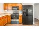 Well-equipped kitchen featuring wood cabinetry and modern black appliances including microwave, oven, and refrigerator at 523 Tribune Dr, Charlotte, NC 28214