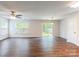 Spacious living room featuring hardwood floors, neutral walls, ceiling fan, window and sliding glass door at 523 Tribune Dr, Charlotte, NC 28214