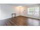Open living room with hardwood floors, white walls and a window with natural light and a front door at 523 Tribune Dr, Charlotte, NC 28214