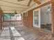 Covered back porch featuring wood flooring, fan, and exterior brick wall, with opening into a living space at 6401 Montpelier Rd, Charlotte, NC 28210