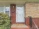 Close-up of the front door with brick and stone accents, featuring a 'hello' welcome mat at 6401 Montpelier Rd, Charlotte, NC 28210