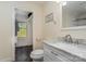 This bathroom has a walk in closet with a window, a toilet and a sink with a mirror hung above at 6419 Gilead Rd, Huntersville, NC 28078
