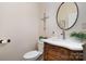 This half bathroom offers an ornate wooden vanity and decorative mirror and wall hangings at 6419 Gilead Rd, Huntersville, NC 28078