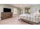 Spacious bedroom featuring neutral colors, carpet, natural light, ceiling fan and a dark wood dresser with TV at 6419 Gilead Rd, Huntersville, NC 28078