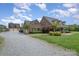 Spacious brick home with a large, well-maintained front lawn and a detached garage on a sunny day at 6419 Gilead Rd, Huntersville, NC 28078