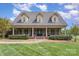 Charming brick home with a welcoming front porch, manicured lawn, and mature landscaping at 6419 Gilead Rd, Huntersville, NC 28078